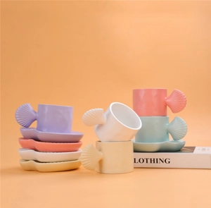 Artistic stack of colorful ceramic mugs and shell-shaped saucers in various pastel tones