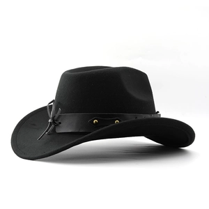 Detail of black western cowboy felt hat featuring leather band and gold rivet accents