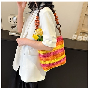 Detail of colorful woven shoulder bag featuring bohemian wooden bead strap accents
