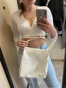 Detail of white canvas tote bag with yellow daisy embroidery for casual summer use