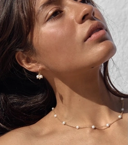 Detail of 18K gold plated necklace and matching pearl earrings on a female model
