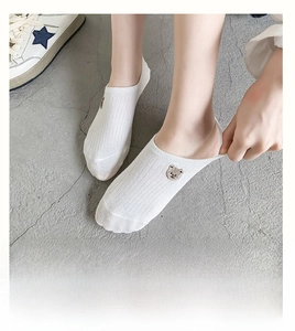 Detail of white cotton no-show socks with brown bear embroidery and ribbed texture