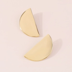 Macro shot of minimalist gold semi-circular earrings with a high-polished mirror finish