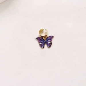 Close-up of purple alloy butterfly pendant with metal ring for DIY dreadlock hair accessories