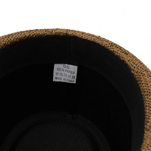 Internal view of brown straw fedora hat featuring sweatband and 100% paper material label