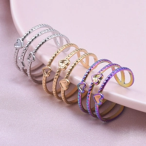 Detailed view of heart rings with beaded texture in gold, silver, and rainbow colors
