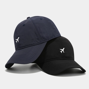Navy and black baseball caps with white airplane embroidery and curved brim