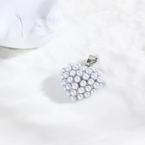 Gros plan d'un pendentif en forme de cœur avec perles blanches et fermoir en argent