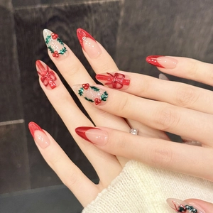 Christmas themed red press-on nails with almond shape, festive wreath and bow designs