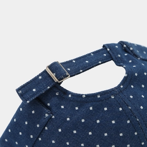 Macro detail of blue polka dot denim cap showing fabric texture and adjustable metal buckle