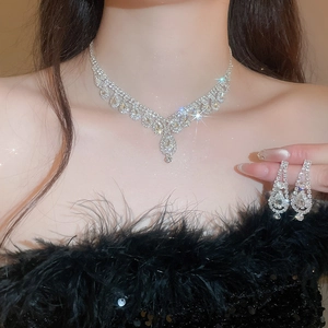 Close-up of diamond teardrop tassel necklace and earrings set worn by a model