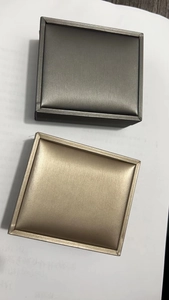 Dettaglio di scatole portagioie quadrate in oro champagne e grigio canna di fucile