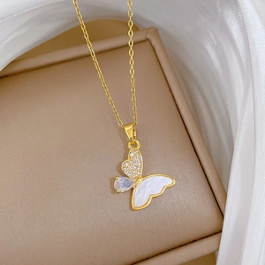 Macro shot of gold butterfly pendant featuring mother-of-pearl and sparkling zircon stones