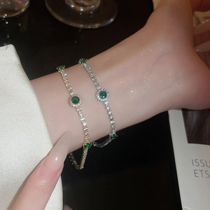 Détail de bracelets tennis élégants avec pierres vert émeraude sur soie douce