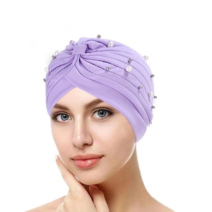 Detail of purple turban hat featuring crossover pleats and white pearl embellishments