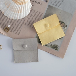 Flat lay of yellow and grey microfiber envelope pouches for jewelry storage