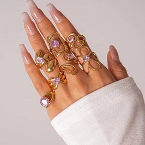 Close-up of 8-piece vintage gold-plated ring set with purple zircon stones on hand