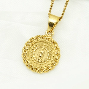 Macro shot of 18K gold plated Virgin Mary pendant with star details and braided frame