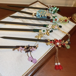 Close-up of vintage wooden hairpins with metallic flowers and colorful tassels