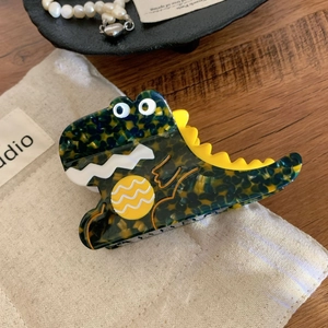 Primo piano di un fermaglio per capelli a forma di dinosauro in acetato tartarugato