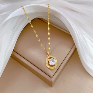 Luxurious gold titanium necklace with interlocking double rings and zircon on a jewelry box