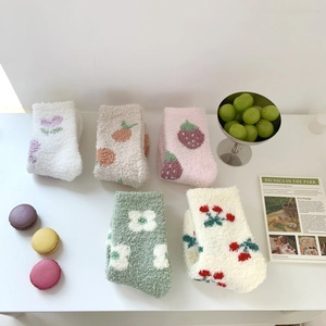 Detail of five pairs of thick coral fleece socks with colorful fruit and flower patterns