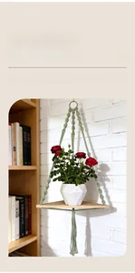 Detail of handwoven light green cotton rope shelf with triangular natural wood base