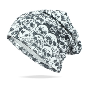 Close-up of slouchy beanie with white skull prints on grey knitted fabric texture