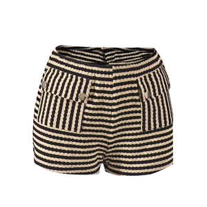 Detailopname van zwart-wit gestreepte tweed shorts met hoge taille en metalen knopen