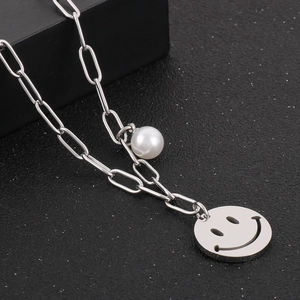 Detail of silver stainless steel paperclip chain necklace with smiley face and pearl