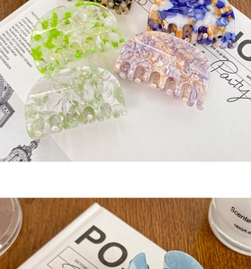 Detailed view of acetate hair claws in pastel marble colors on a stylish background