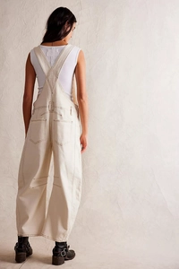 Detail of cream white denim overalls showing back pockets and wide-leg worker style