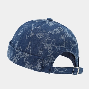 Retro denim docker cap in dark blue with white floral graffiti and adjustable metal buckle