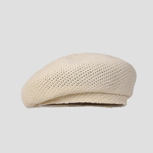 Detail of beige knit beret showing fine mesh breathable weave and natural oat tone texture