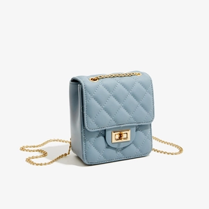 Detail of light blue quilted mini crossbody bag with gold chain strap and square lock