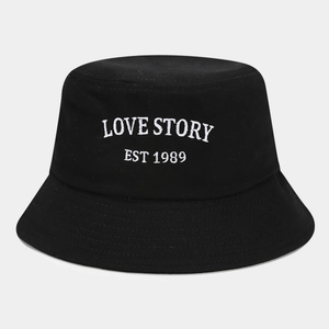 Close-up of Love Story white embroidery on a black cotton bucket hat with parallel stitching