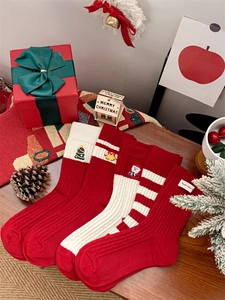 Gros plan de chaussettes de Noël rouges et blanches avec motifs festifs brodés