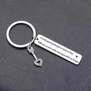 Macro shot of silver stainless steel keychain for principals on dark leather surface