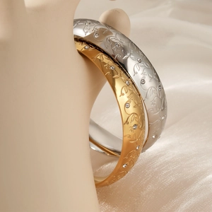 Women's stainless steel wide bangle with floral vine engraving and cubic zirconia stones