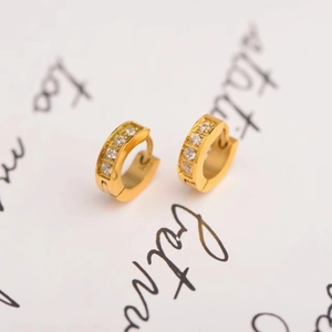 Detail of 18K gold-plated stainless steel huggie earrings with cubic zirconia inlay