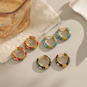 Three pairs of enamel hoop earrings with floral patterns in red, blue, and black colors
