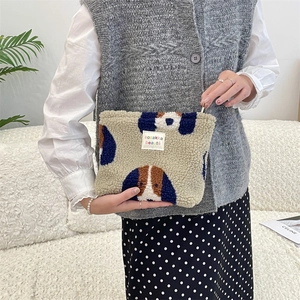 Beige plush makeup bag with beagle dog pattern and zipper closure in lifestyle setting