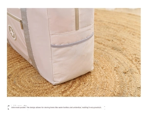 Detail view of pink travel bag with a functional mesh side pocket for water bottles