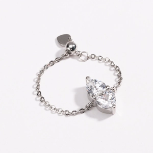 Detail of adjustable silver chain ring with two pear-cut cubic zirconia and heart charm