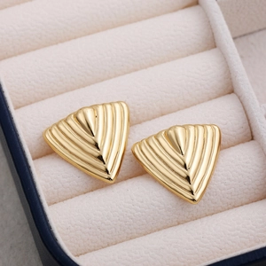 Detail of 18K gold geometric triangle stud earrings with textured surface in a velvet box