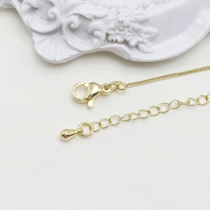 Detailed macro view of 14k gold adjustable box chain with lobster clasp and extender