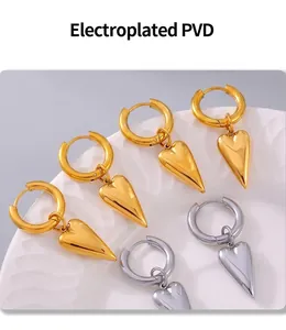 Macro shot of PVD electroplated gold and silver heart earrings on a white plate