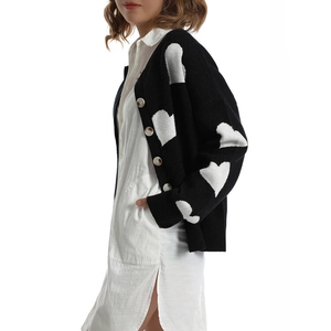 Detail of heart pattern knit cardigan with contrast stitching and cream buttons
