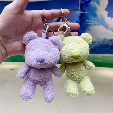 Close-up of purple and light green plush astronaut bear keychains with metal clips