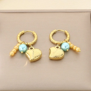 Gold hoop earrings featuring heart charms with blue and gold pearl beads on display